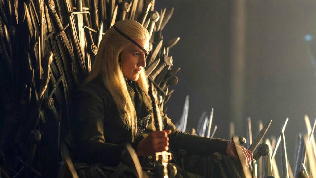 Cosplayer with Long Blonde Hair Sits on the Iron Throne a Throne Carved from Swords in a Dimly Lit Scene