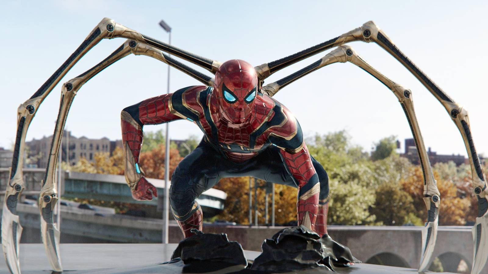 Spider man Crouching in Red Suit with Four Metallic Robotic Arms Extended Behind Him on a City Rooftop Set