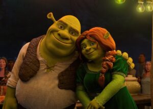 Shrek and Princess Fiona Smile Together at a Nighttime Village Celebration with Villagers in the Background