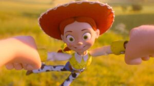 Toy Jessie Doll from Toy Story Being Swung by Two Hands in a Sunlit Grassy Field