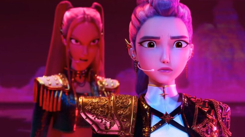 Two Animated Warriors in Ornate Armor Stand on a Pink lit Stage Foreground Character Looks Worried While Wearing a Headset Mic and Armor Details Are Gold and Blue