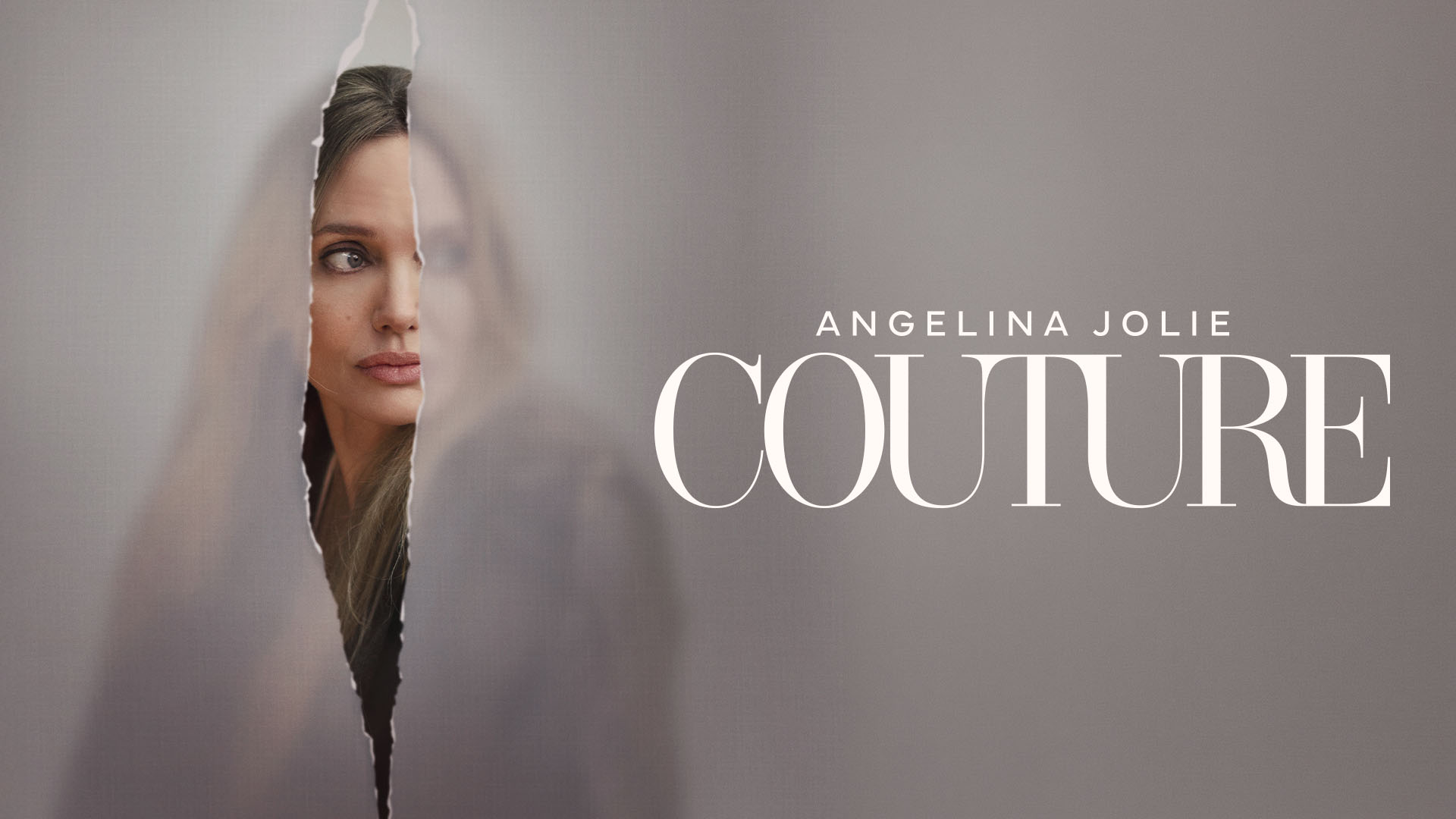 Angelina Jolie Peeking Through a Torn Paper in a Muted Grey Ad for Couture Fashion