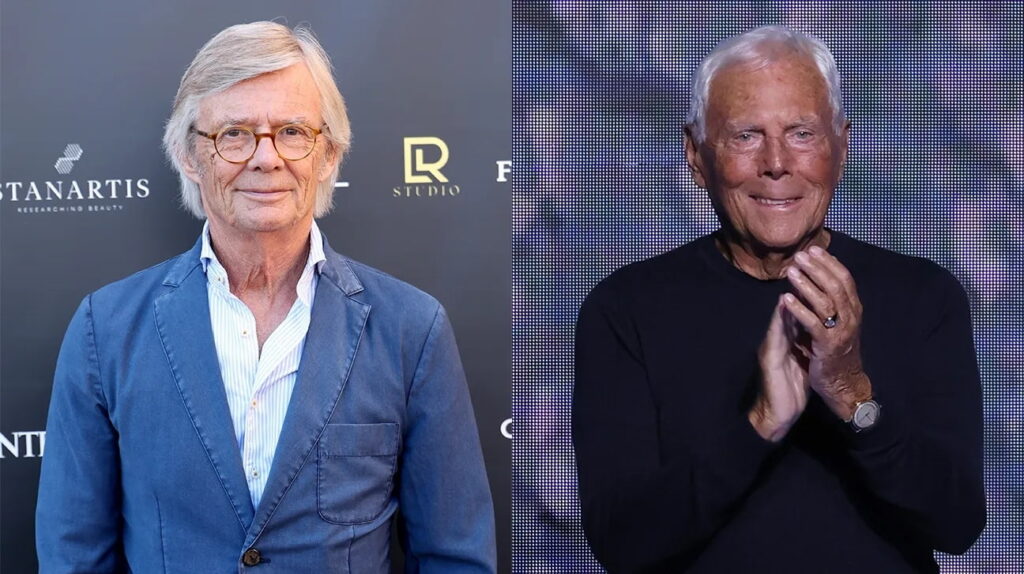 Two Older Men at an Event Left Man with Gray Hair and Glasses in a Blue Blazer Right Man in a Black Shirt Clapping on a Stage Backdrop