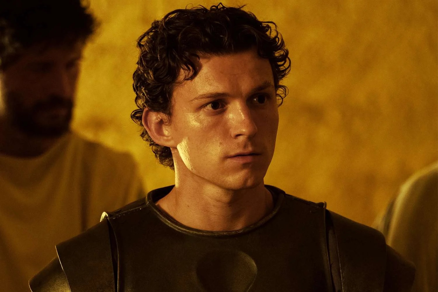 Young Man in Dark Armor Gazes to the Right in a Warm Amber lit Scene