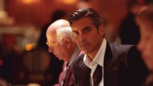 Man in a Dark Suit and White Shirt at a Dimly Lit Formal Event Looking Toward the Camera