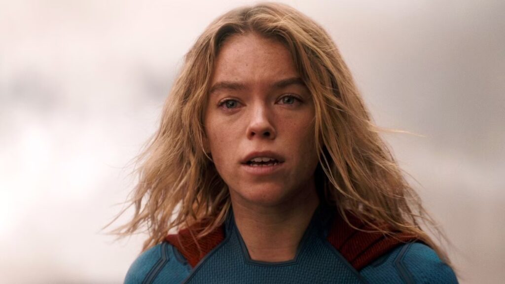 Close up of a Blonde Woman in a Blue Superhero Suit with a Red Cape Looking Worried