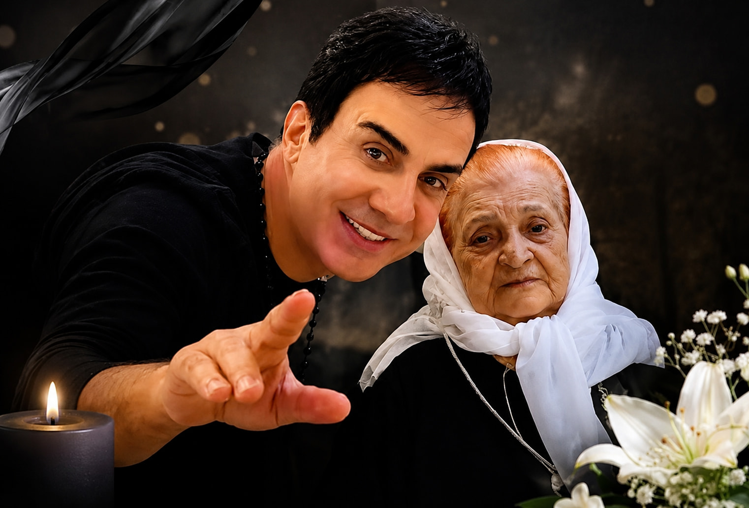 Man in Black Extends His Hand Toward the Camera Beside an Elderly Woman in a White Headscarf with a Lit Candle and Flowers on the Table to the Side