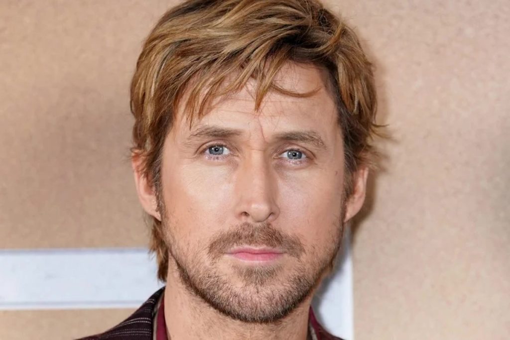 Close up Portrait of a Man with Blond Hair Blue Eyes and Light Stubble Looking at the Camera on a Beige Background