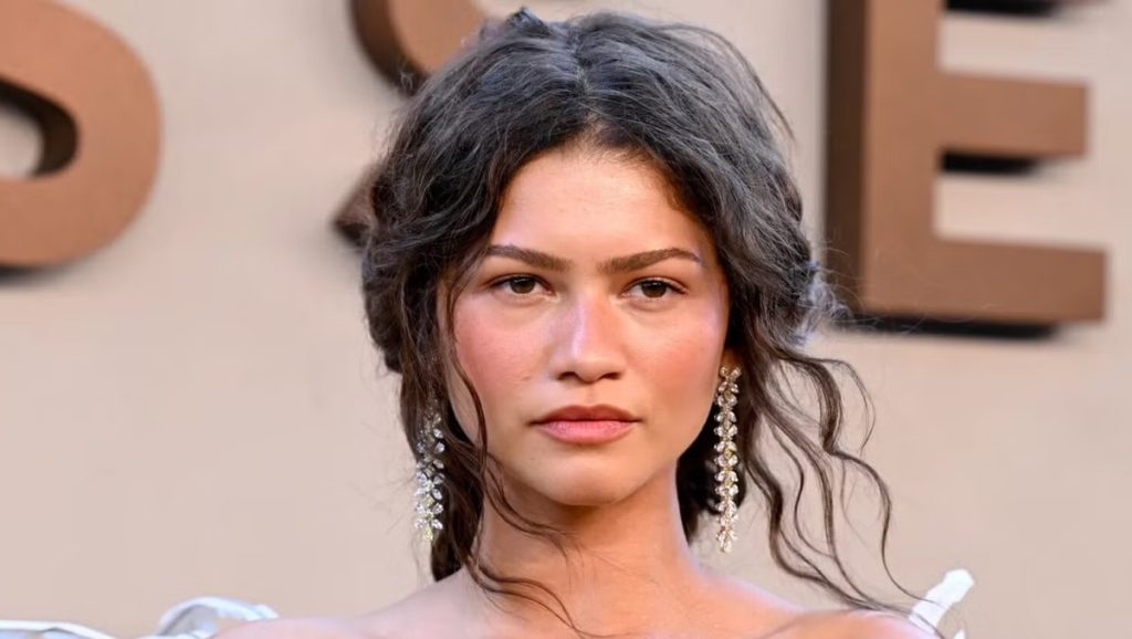 Woman on a Red Carpet Looking at the Camera Wearing Long Crystal Chandelier Earrings and Updo Hairstyle