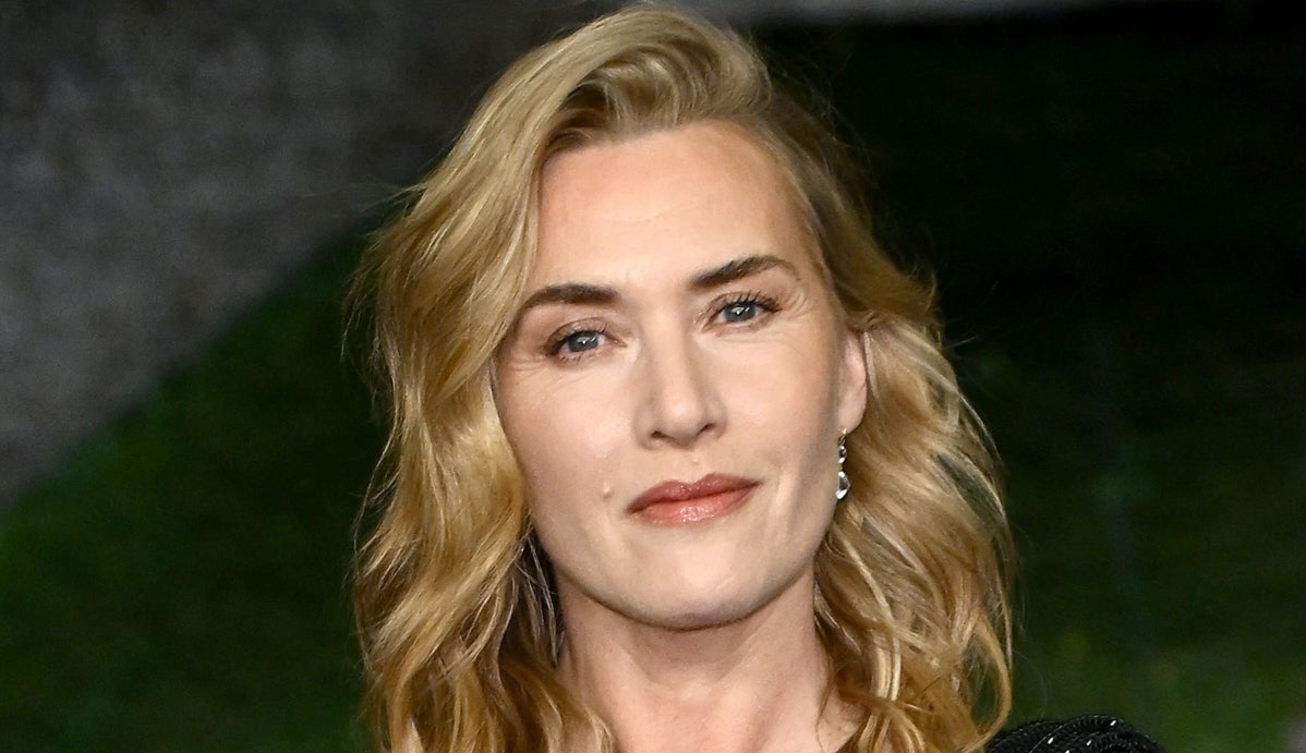 Close up Portrait of a Smiling Blonde Woman with Wavy Hair Outdoors Wearing Subtle Makeup and an Earring
